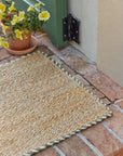 Braided Jute Doormat With Green Trim at Front Stoop With Yellow Flowers